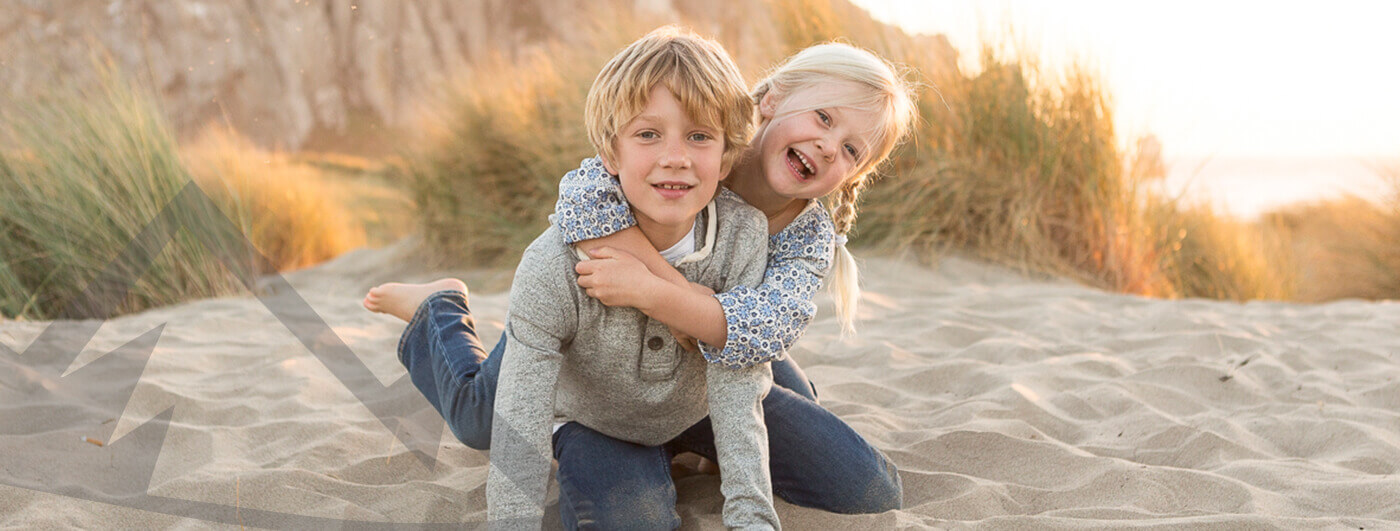 Two laughing kids on beach
