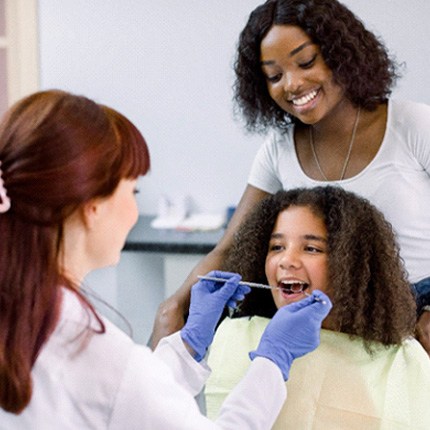 teen getting her teeth examined