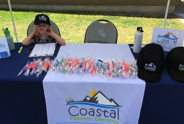 Child at Coastal Pediatric Dentistry information table