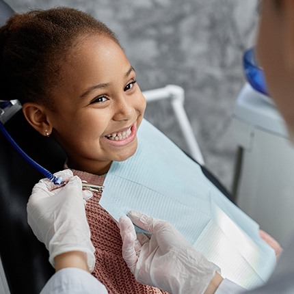 little girl smiling in the dentist chair