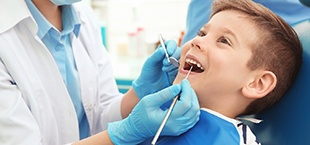 little boy having his teeth examined by a dentist