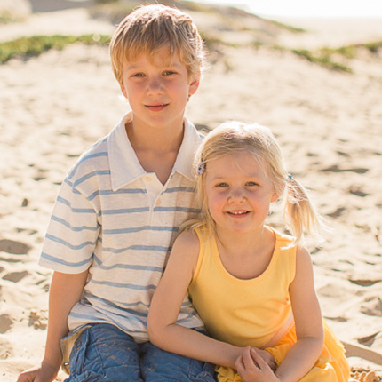 Brother and sister smiling on the beach