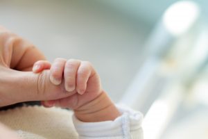 Tiny baby holding mother’s hand.