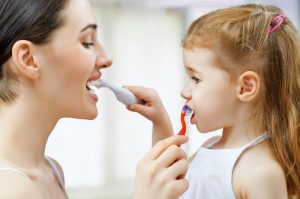 Mom and daughter brushing their teeth. 