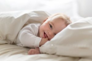 smiling baby on a bed