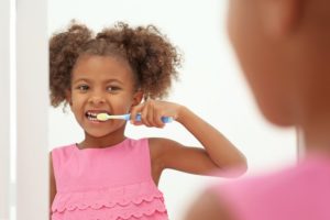 young girl brushing teeth